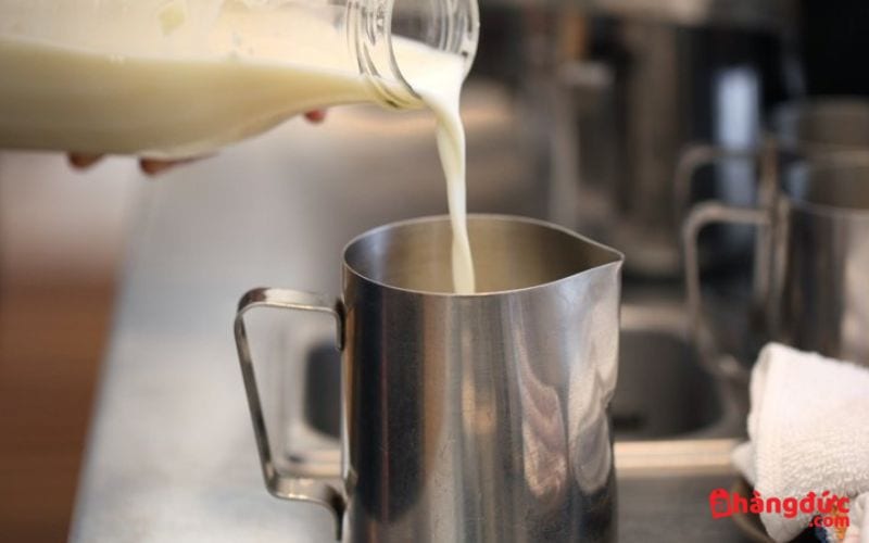 Đổ sữa ra ca đánh sữa để đánh bọt sữa cappuccino